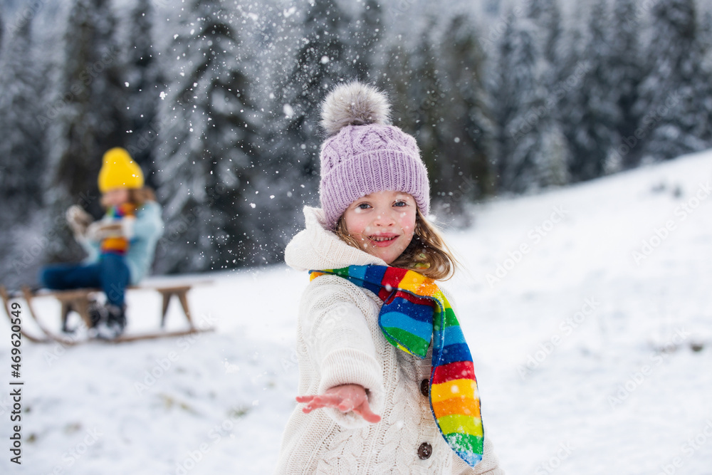 Lovely child girl playing snowball fight on a winter walk in snow nature.