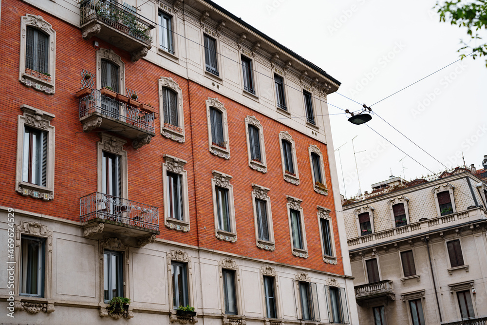 Facade of the building with stucco moldings on the balconies. Milan, Italy