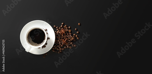 coffee cup and coffee beans on dark background