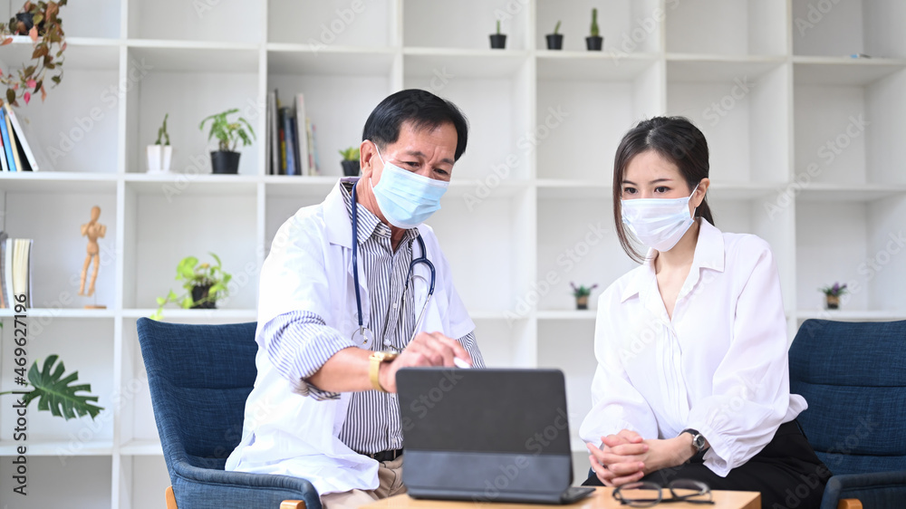 Obraz premium Senior doctor wearing white uniform giving advice to a female patient in hospital.