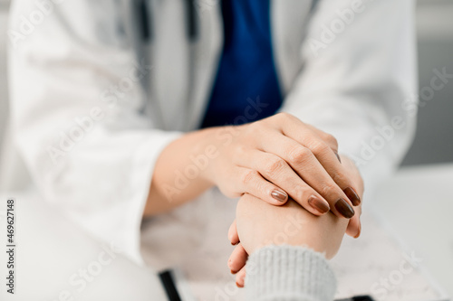 Close-up view of woman professional doctor touching hand patient reassuring concern medication and treatment method with a patient at room hospital, medical health care concept.