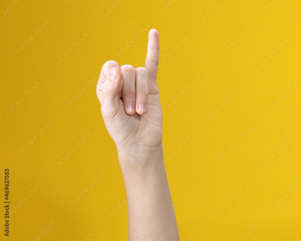 Naklejka premium Partial image of person showing one little finger gesture on yellow background