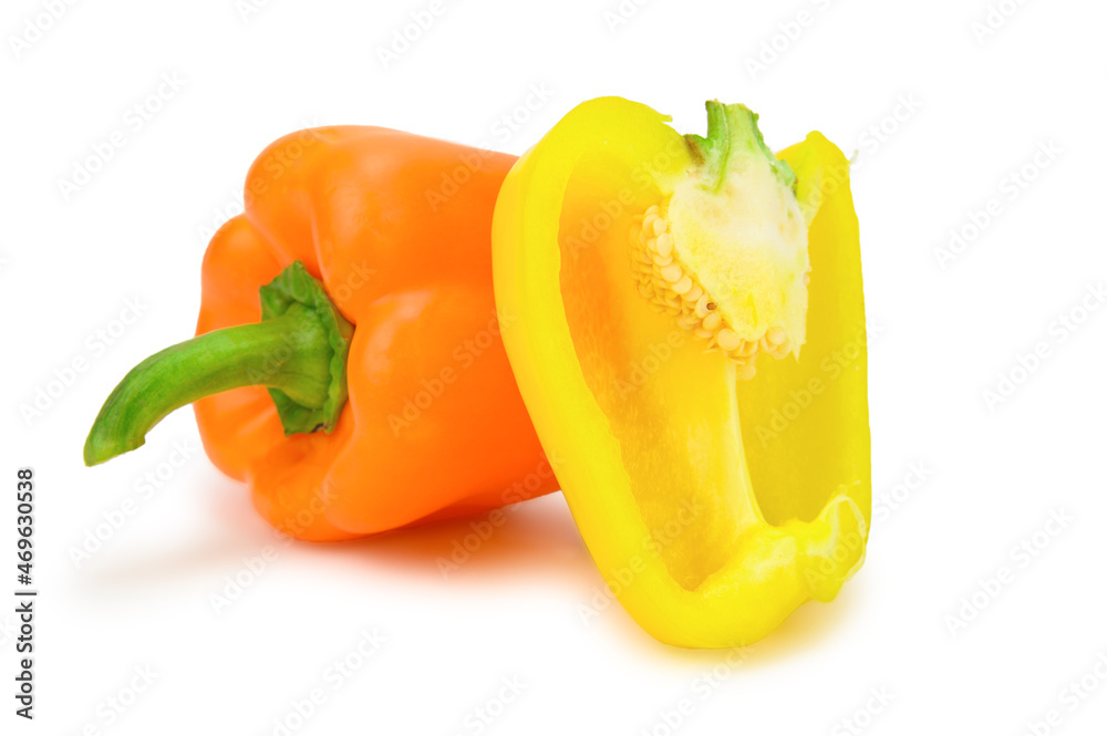 An orange bell pepper lying on its side and a half of a yellow pepper placed vertically An orange bell pepper lying on its side and a half of a yellow pepper placed vertically