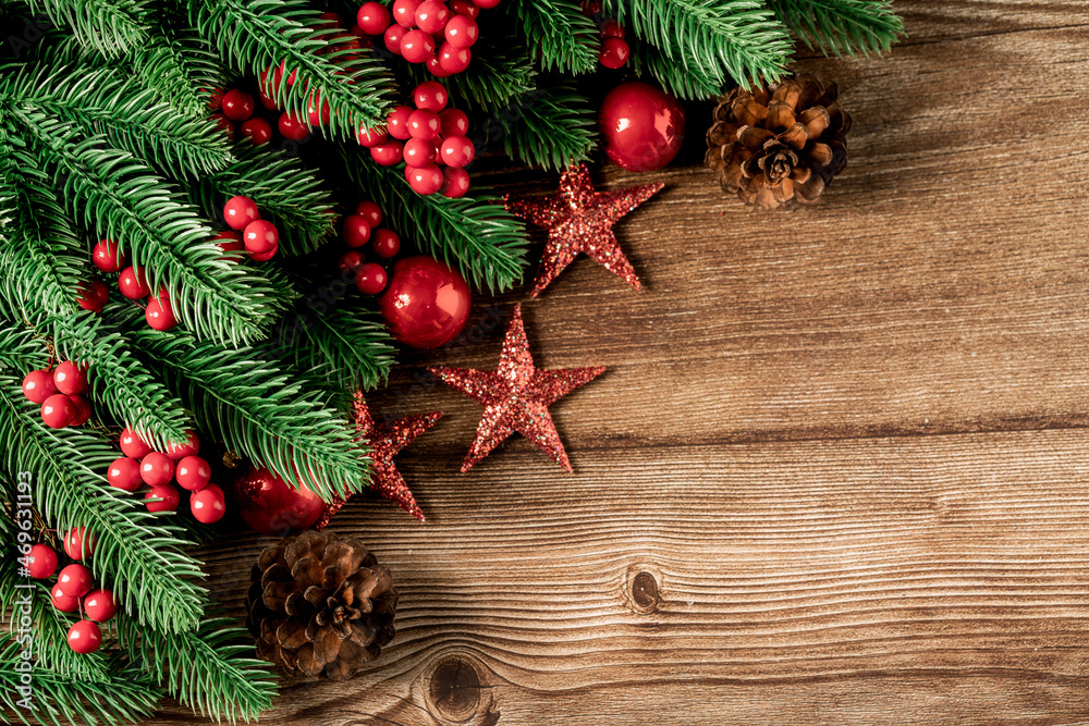 Top view of green branches, pine cones, Christmas gift box, stars, red balls, red berries on dark wooden background, Banner, copy space, Christmas or New Year background concept. Top view of green branches, pine cones, Christmas gift box, stars, red balls, red berries on dark wooden background, Banner, copy space, Christmas or New Year background concept.