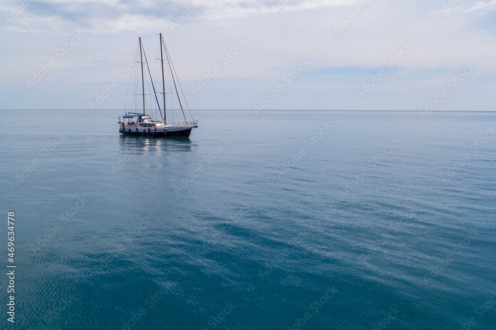 Fototapeta premium Sailboat sailing in the morning with blue cloudy sky. Luxury yacht in open waters with beautiful clouds