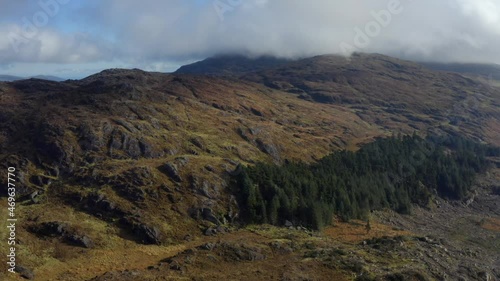 Carlingford Lough, Louth, Ireland, October 2021. Drone tracks west over rugged mountains revealing a view of the lough with Mourne mountains in the distance. photo