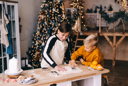 two boys are cooking christmas cookies