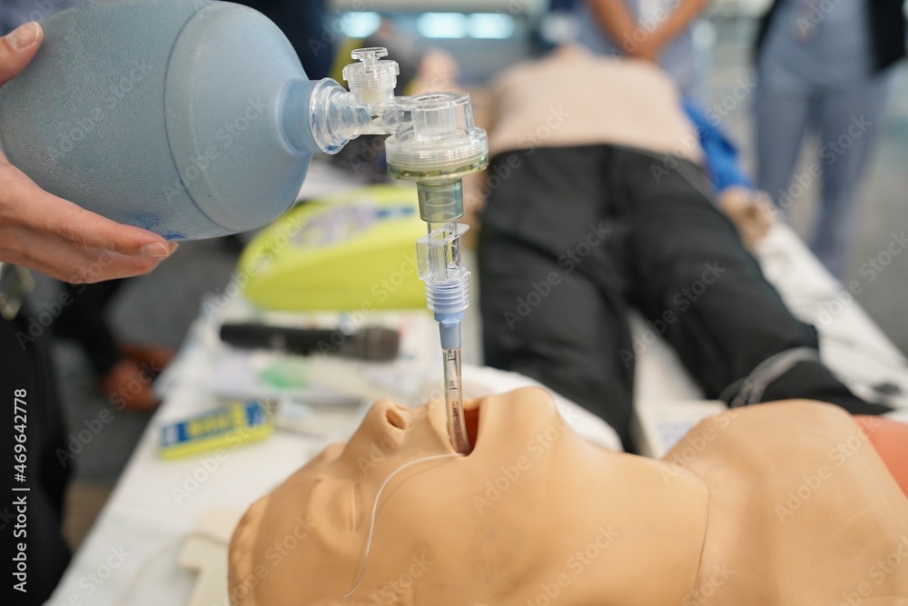 A healthcare professional demonstrates intubation on a manikin using a