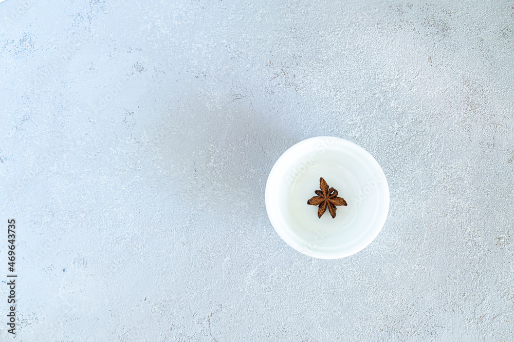Anise on a white plate, on a gray background. High quality photo