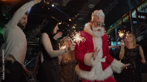 Happy young people, Santa Claus dancing at costume New Year celebration party