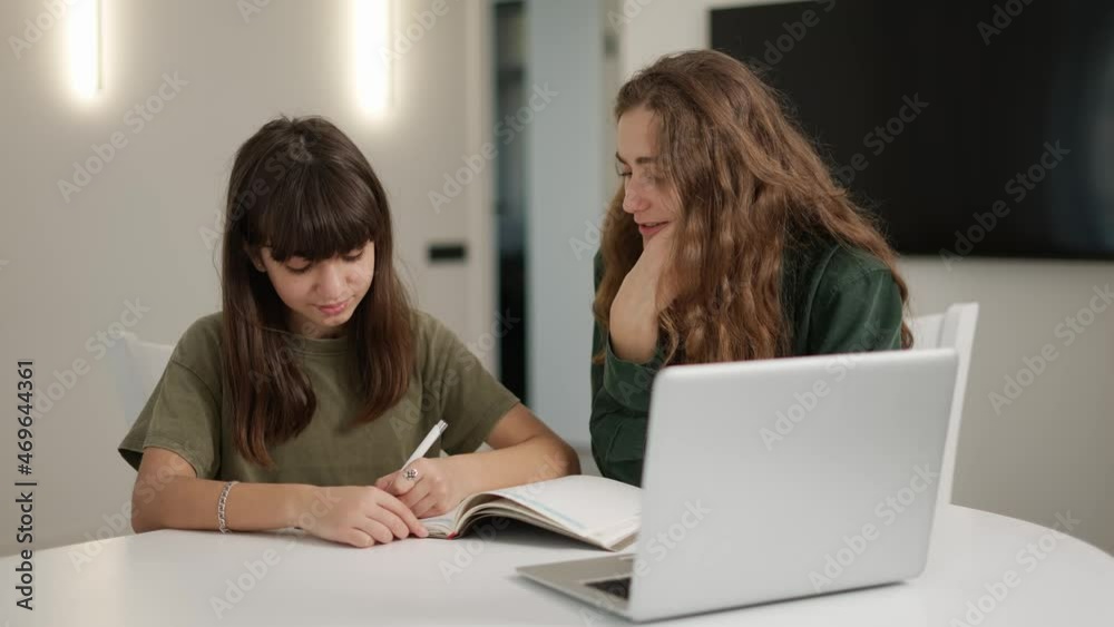 Teen student girl has individual lesson from young woman teacher with laptop Teen student girl has individual lesson from young woman teacher with laptop