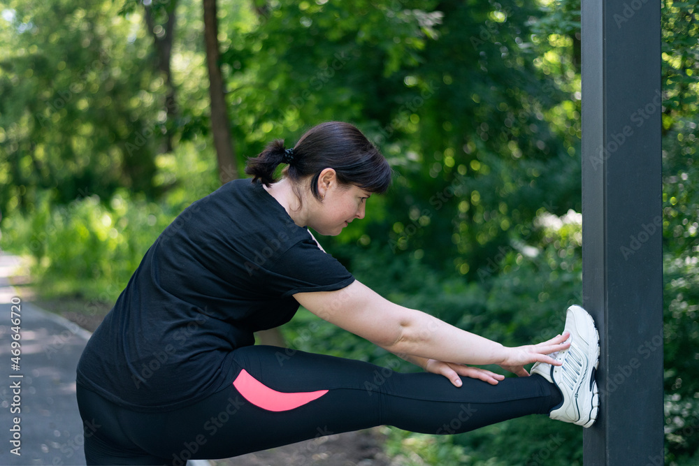 Young plus size woman doing warm-up in the park before jogging. Going to lose extra pounds. Young plus size woman doing warm-up in the park before jogging. Going to lose extra pounds.