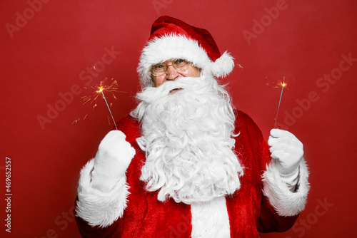 Caucasian Santa Claus holding Christmas sparklers © gpointstudio