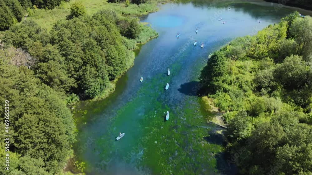 Group of paddlers are paddling along azure river. Vacationers enjoy the beauty Group of paddlers are paddling along azure river. Vacationers enjoy the beauty