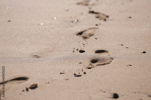 Human foot prints on golden beach sand