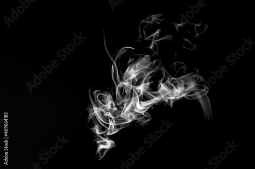 Abstract white smoke on black background. Monochrome, grayscale photography of illuminated incense. Moody feeling. Dark backdrop, graphic resource for montage, overlay or texture, copy space.