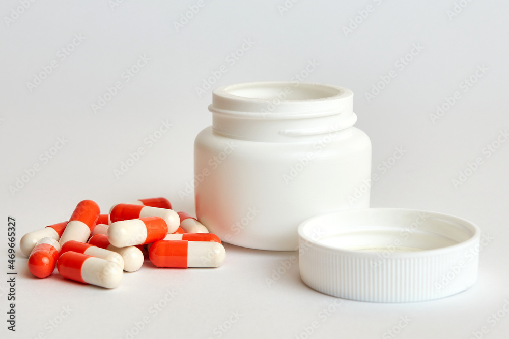 Medical capsules next to the original plastic jar. Medicines. Medical capsules next to the original plastic jar. Medicines.