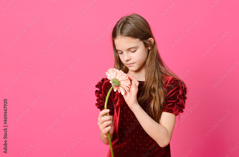 white teen girl with long hair in a red dress with a flower on a pink background white teen girl with long hair in a red dress with a flower on a pink background