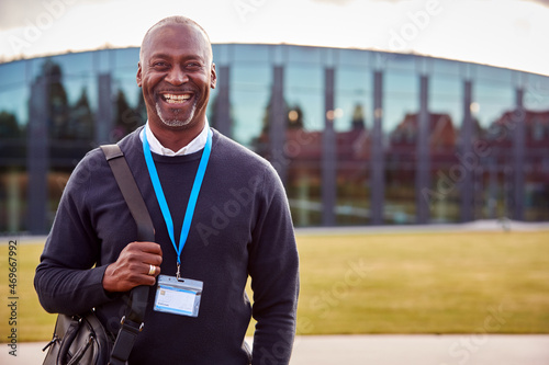 Portrait Of Male University Or College Tutor Outdoors With Modern Campus Building In Background photo