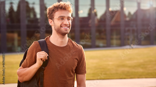 Portrait Of Male University Or College Student Standing Outdoors By Modern Campus Building