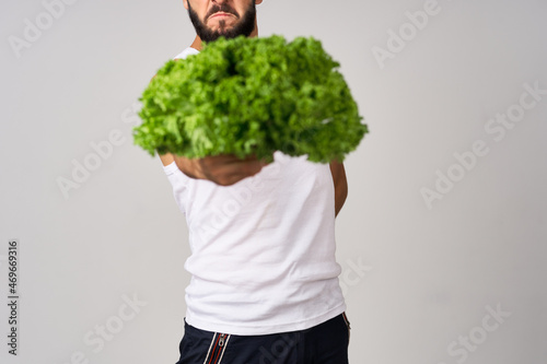 cheerful man in a white t-shirt lettuce leaves healthy food