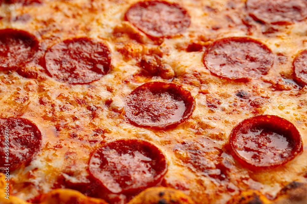 Closeup on pepperoni pizza with salami texture background Closeup on pepperoni pizza with salami texture background