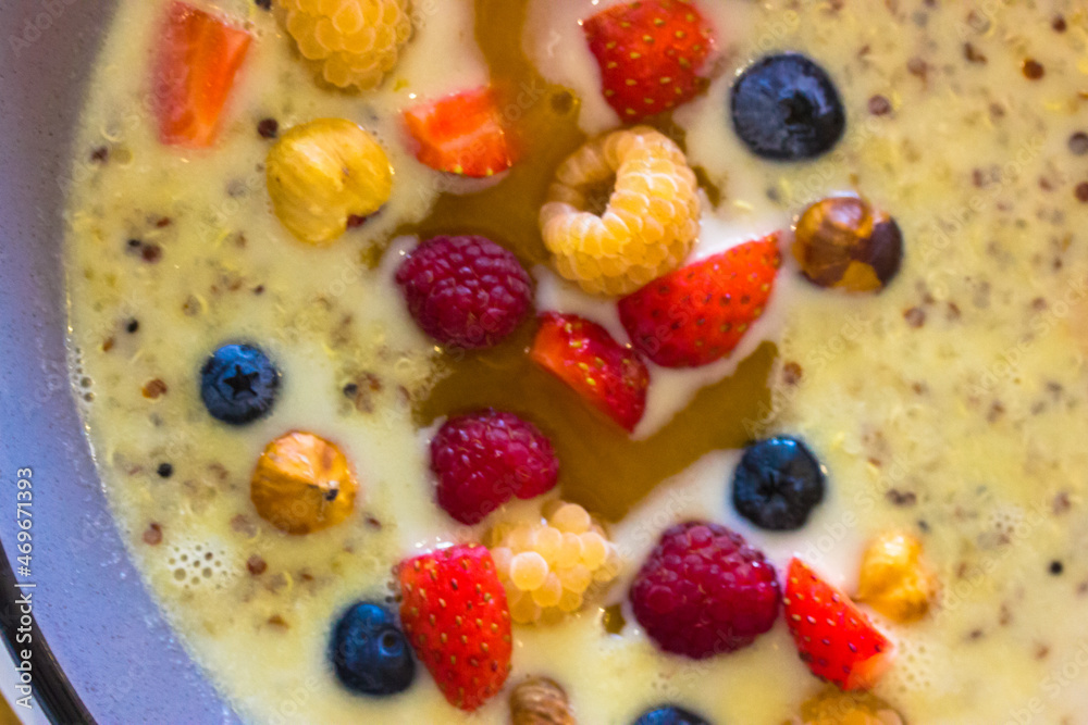 Porridge quinoa with coconut milk, honey and fresh fruit, berries top view. Strawberries, blueberries, yellow raspberries, nuts flat lay. Healthy food concept. Delicious organic breakfast. Trendy meal Porridge quinoa with coconut milk, honey and fresh fruit, berries top view. Strawberries, blueberries, yellow raspberries, nuts flat lay. Healthy food concept. Delicious organic breakfast. Trendy meal
