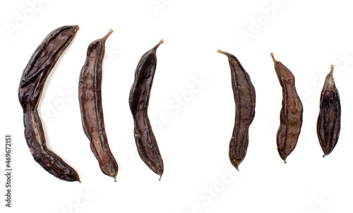 Carob pods lined on white.