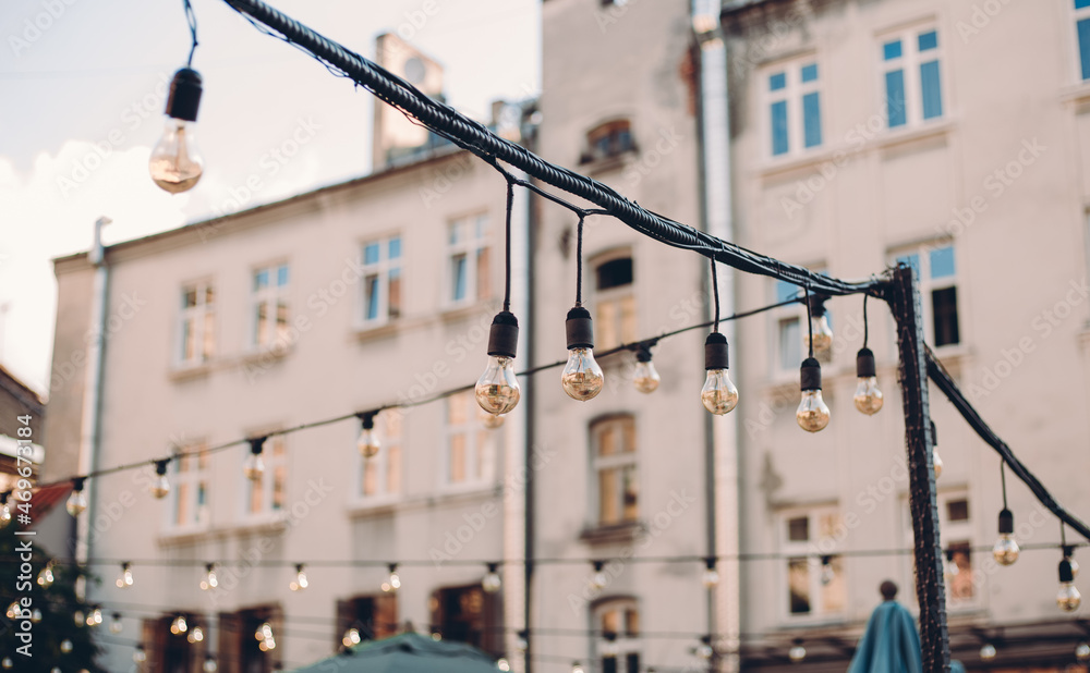 Decorative Outdoor Street electric garland against the sky in the garden, old town