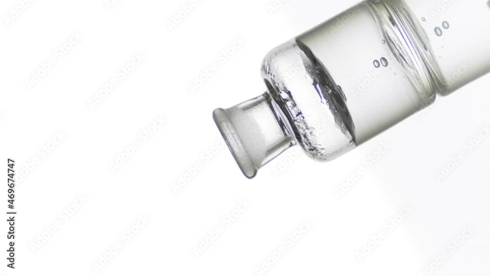 Drop of hyaluronic acid drips into old fashioned bottle with grey transparent liquid on white background | Abstract body care cosmetics with hyaluronic acid formulating concept Drop of hyaluronic acid drips into old fashioned bottle with grey transparent liquid on white background | Abstract body care cosmetics with hyaluronic acid formulating concept