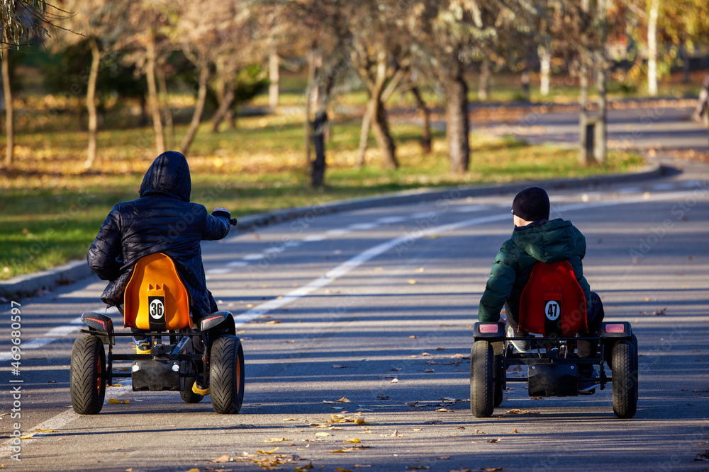 father and son in the park ride bicycles, seen from behind father and son in the park ride bicycles, seen from behind