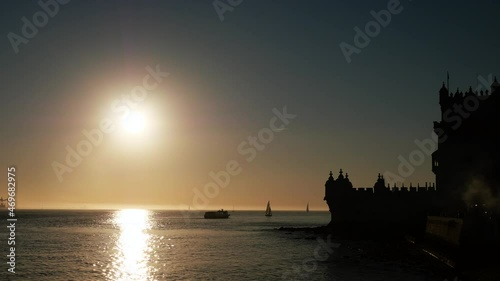 Early dusk at Belém Tower in Lisbon, Portugal. The silhouette of boats are visible on the River Tagus all filmed in 4K.