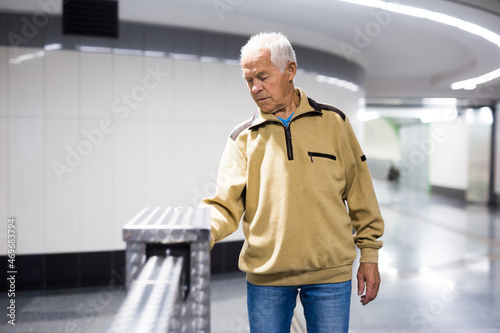 Slika na platnu Elderly passenger pays for a metro ride using mobile phone