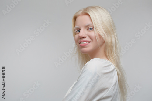 Cute blond scandinavian woman isolated on gray background.