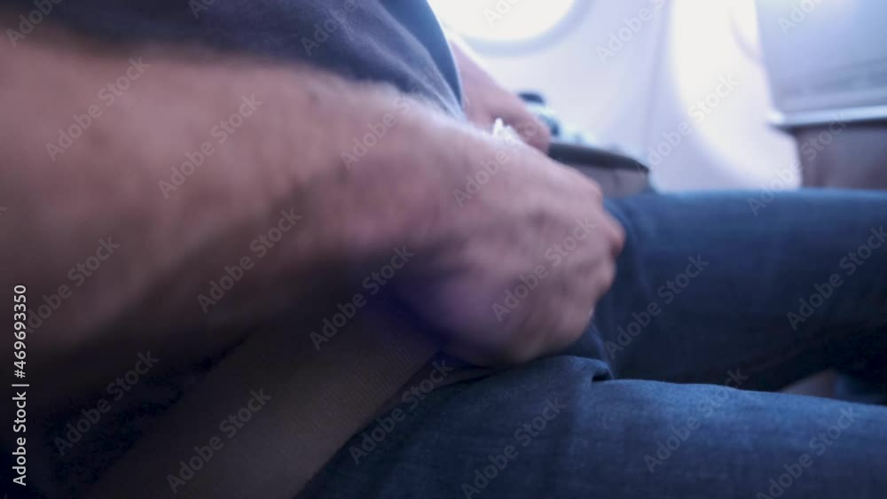 Fasten the seatbelt on the airplane side shot. buckle up on plane. Passengers sitting inside airplane wearing a safety belt while waiting for takeoff. Safe travel importance while traveling on plane Fasten the seatbelt on the airplane side shot. buckle up on plane. Passengers sitting inside airplane wearing a safety belt while waiting for takeoff. Safe travel importance while traveling on plane