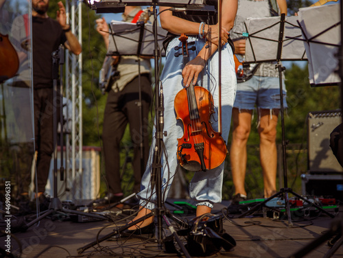 Female violinist standing near music stand outdoors