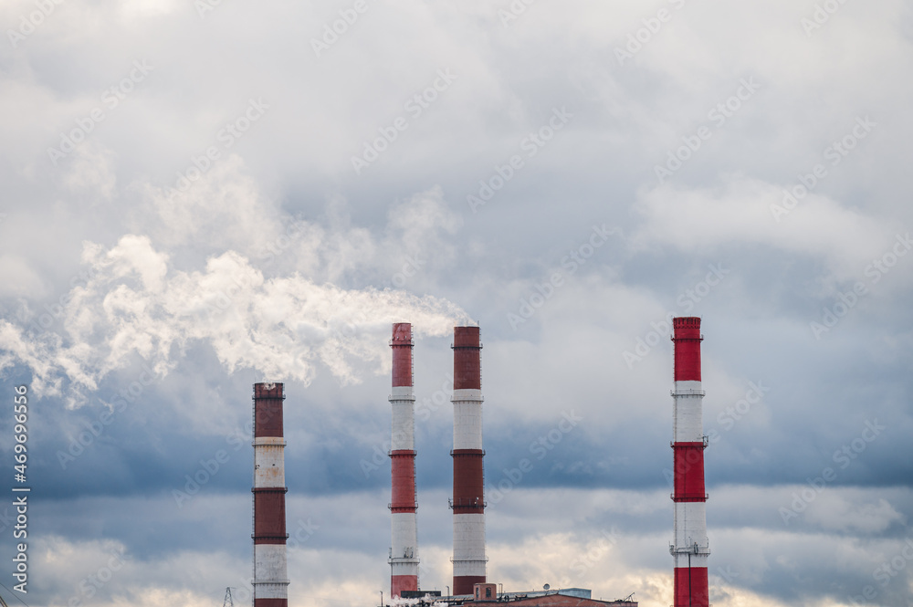 Four pipes of a thermal power plant against a cloudy sky