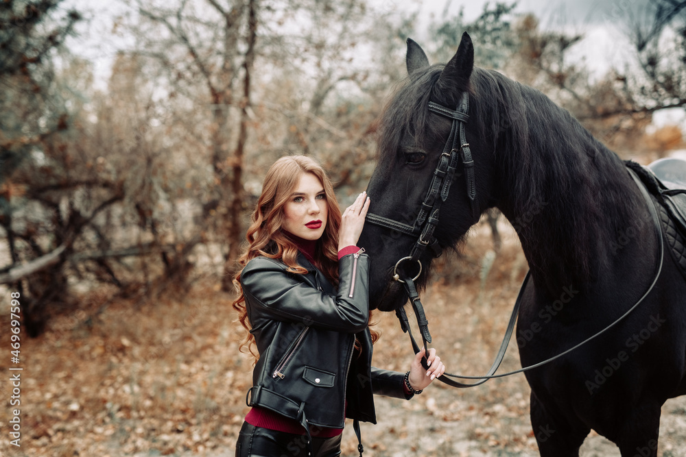 Fototapeta premium Beautiful young woman posing with a horse outdoors, close up