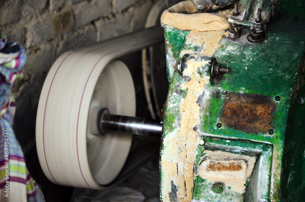 Motion blur picture of a traditional wheat, rice or seeds grinder. Side ...