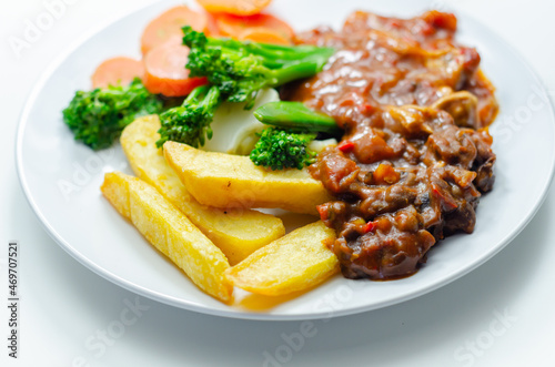 Pulled pork in barbecue style sauce with barbecues style beans with spiced chips and fresh vegetables