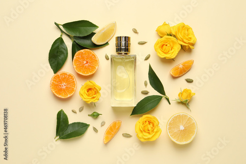 Flat lay composition with bottle of perfume and fresh citrus fruits on beige background