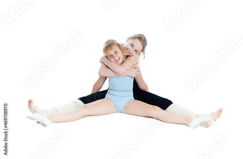 Two sisters gymnasts work together to perform gymnastic exercise. Isolated on white background. photo