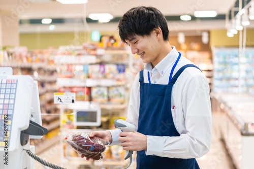 食品スーパーでレジ打ちをするスタッフ