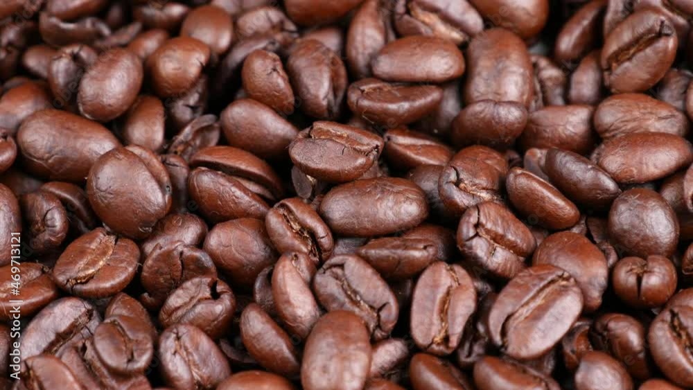Roasted coffee beans spinning, top view. Coffee close up Roasted coffee beans spinning, top view. Coffee close up