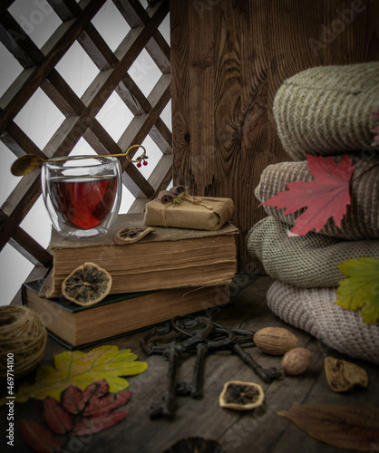 Moscow, October 2021, a cup of tea stands on a book near the window, a stack of sweaters, autumn leaves, lemon lolki