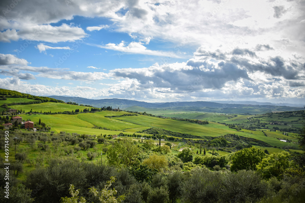 Tuscany, Italy, May 2018, a view from a height of a green valley with olive orchards and a farm