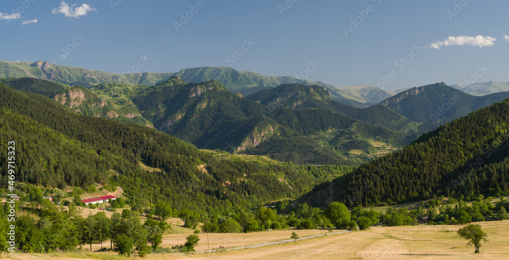 View of the mountains in the summer season. Sunny day in a small village.