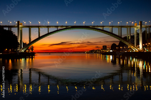 View over the Arrábida bridge at sunset with the lights reflected in the river  photo