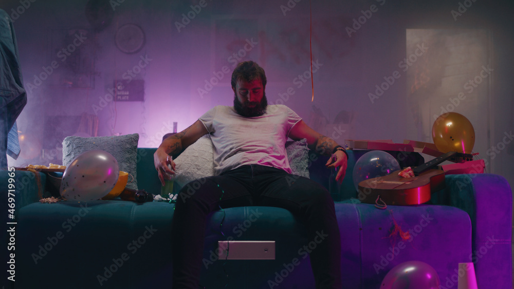 © Framestock - Bearded man sitting on sofa during party