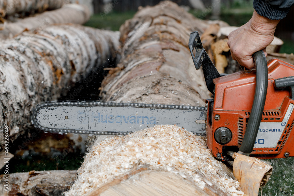 KIROV, Russia - 09.10.2020. Husqvarna 40 Chainsaw. Man saws a log with a  chainsaw, prepares firewood for winter, hard rural work Stock Photo | Adobe  Stock